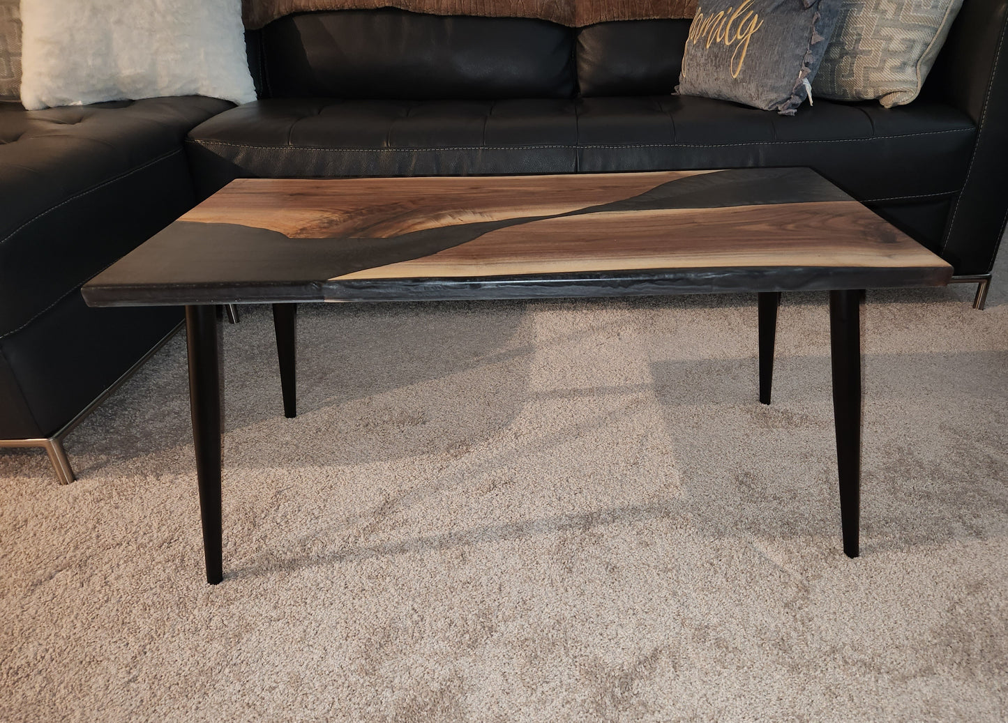 Indulge in the exquisite sophistication of our Walnut and Epoxy Coffee Table. Crafted with premium walnut hardwood and accented with luxurious epoxy, this table is a stunning addition to any space. Elevate your home with this elegant and exclusive piece of functional art.