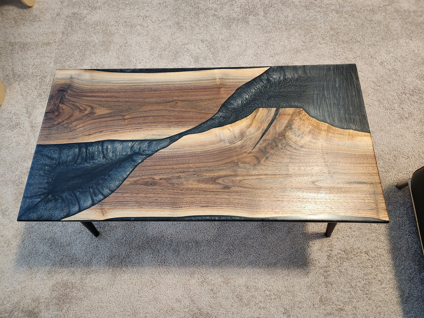 Indulge in the exquisite sophistication of our Walnut and Epoxy Coffee Table. Crafted with premium walnut hardwood and accented with luxurious epoxy, this table is a stunning addition to any space. Elevate your home with this elegant and exclusive piece of functional art.